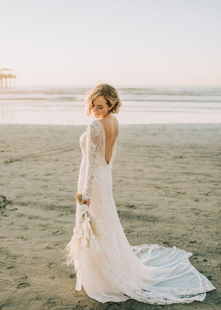 Bride spinning on the beach wearing her boho style wedding dress