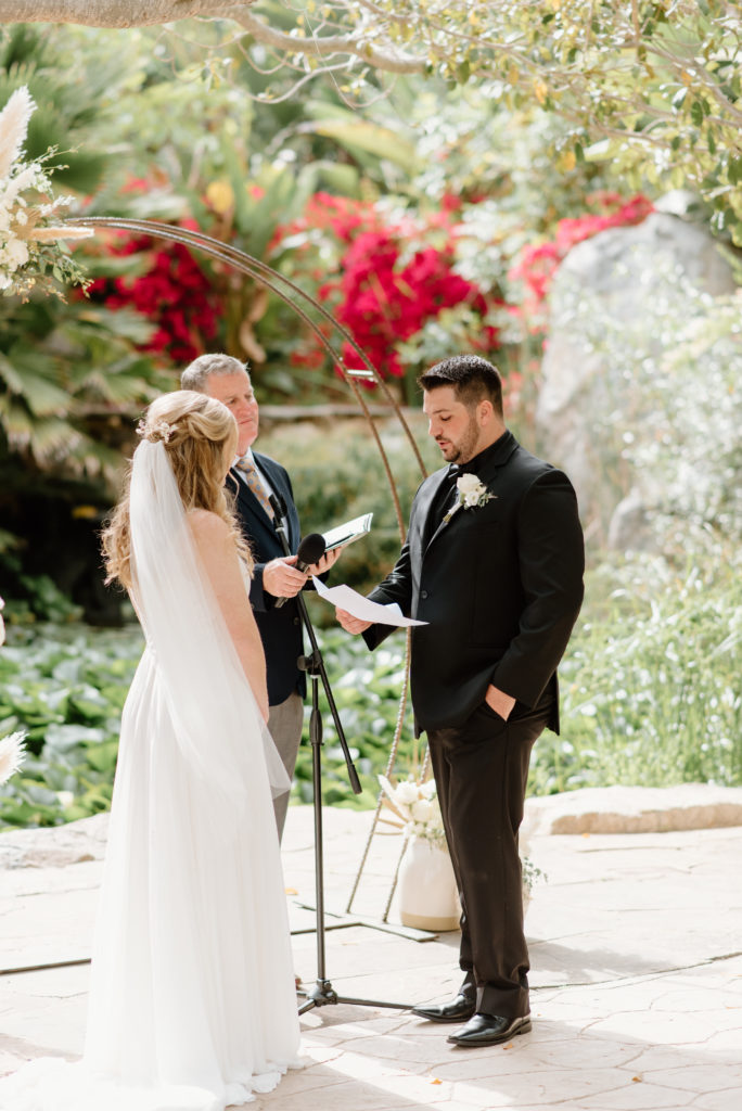 Bride and groom saying their vows to one another during their wedding ceremony at the Botanica Oceanside