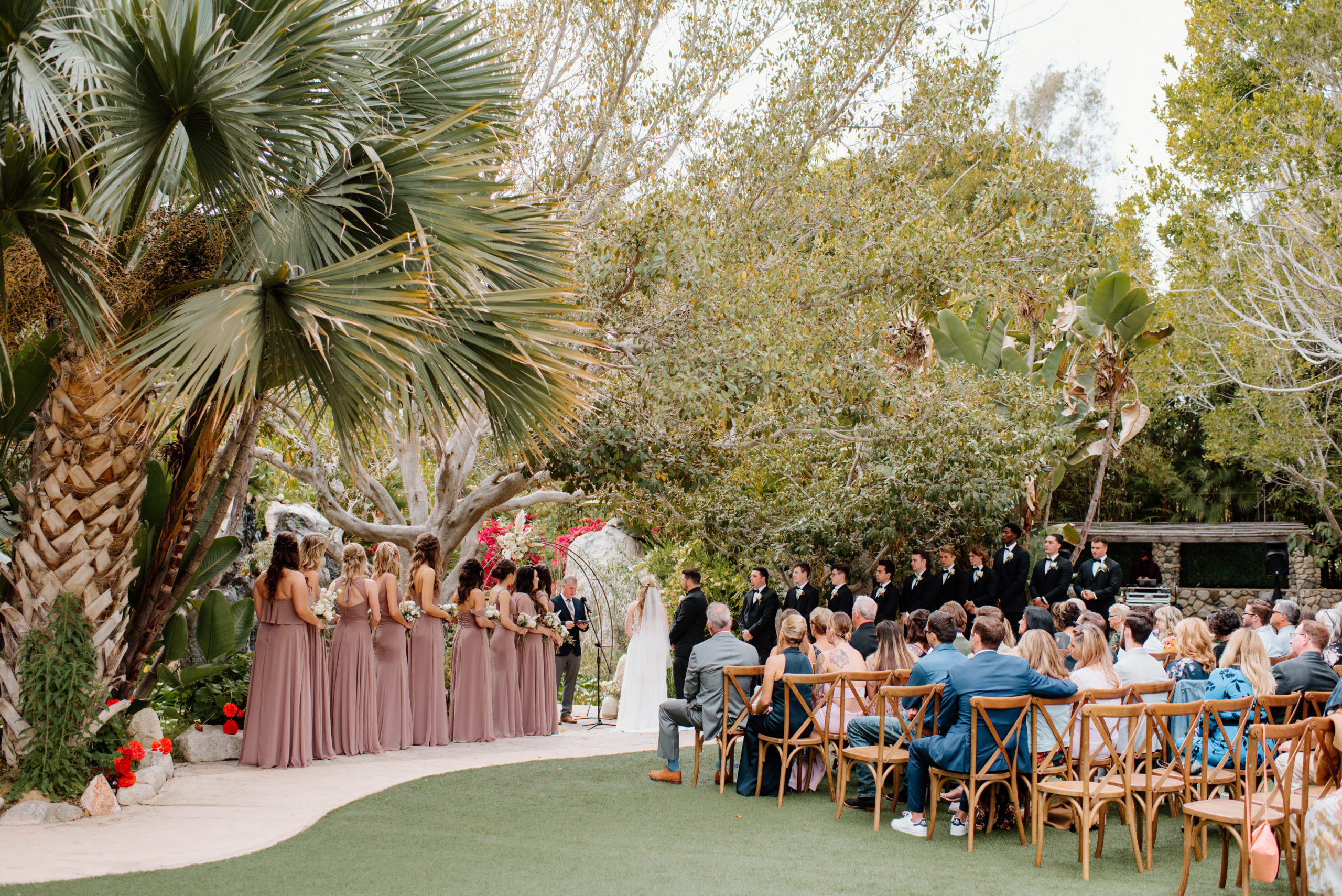 A wide photograph of Brooke and Jayden's wedding ceremony at the Botanica Oceanside.