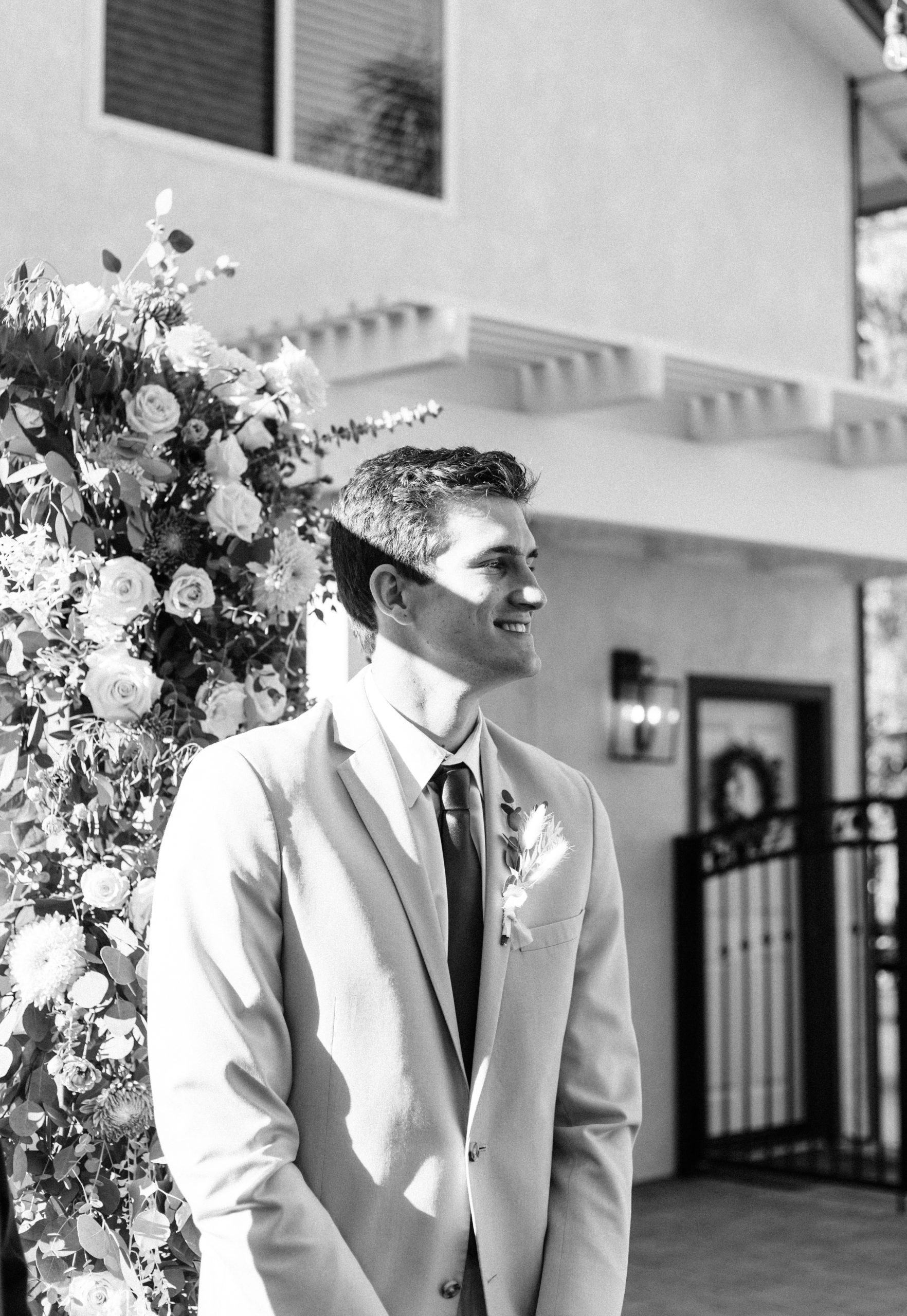 The groom watching the bride walk down the aisle during the wedding ceremony in Temecula