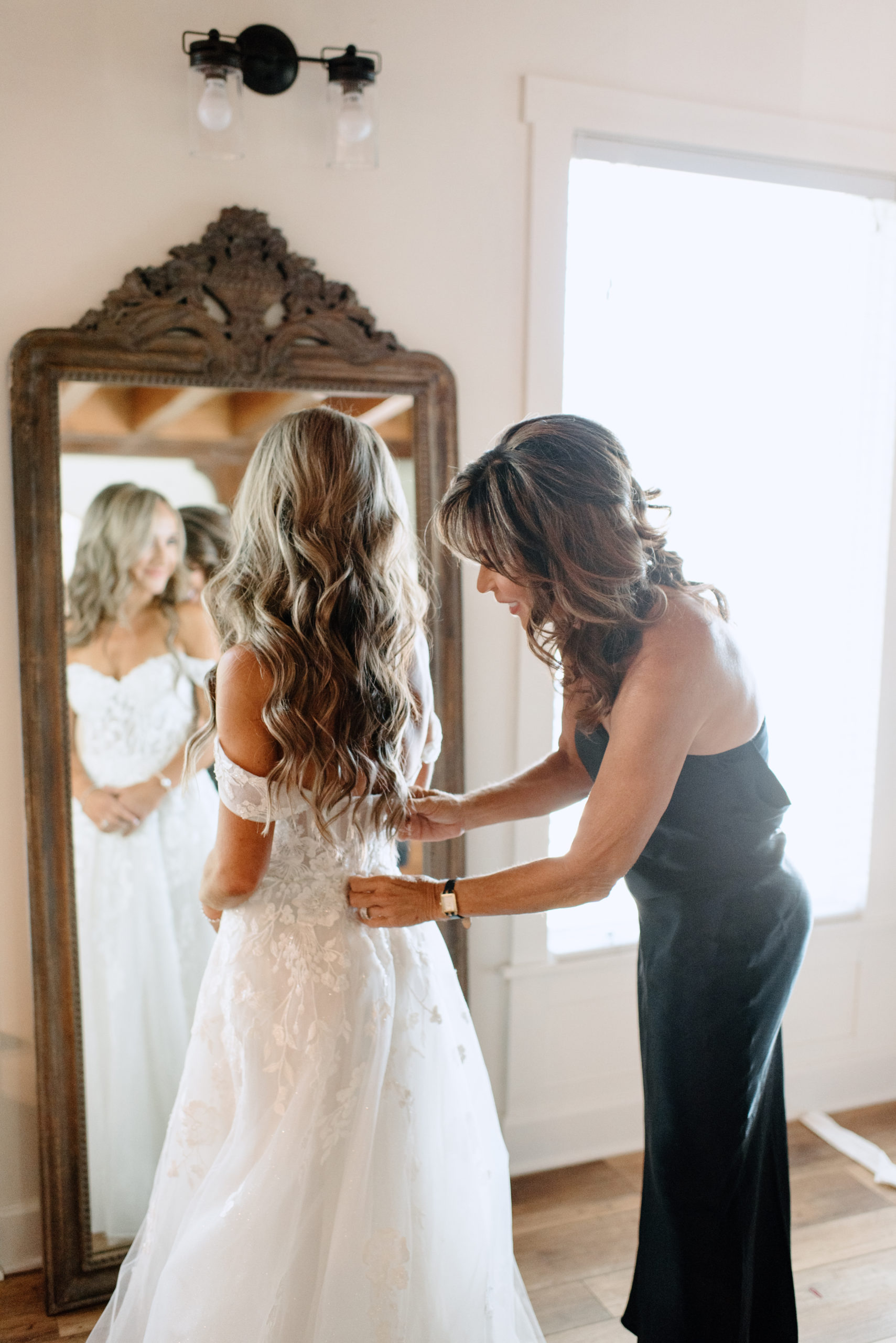 The bride's mom helping the bride get ready in the bridal suite at the Lake Arrowhead wedding venue