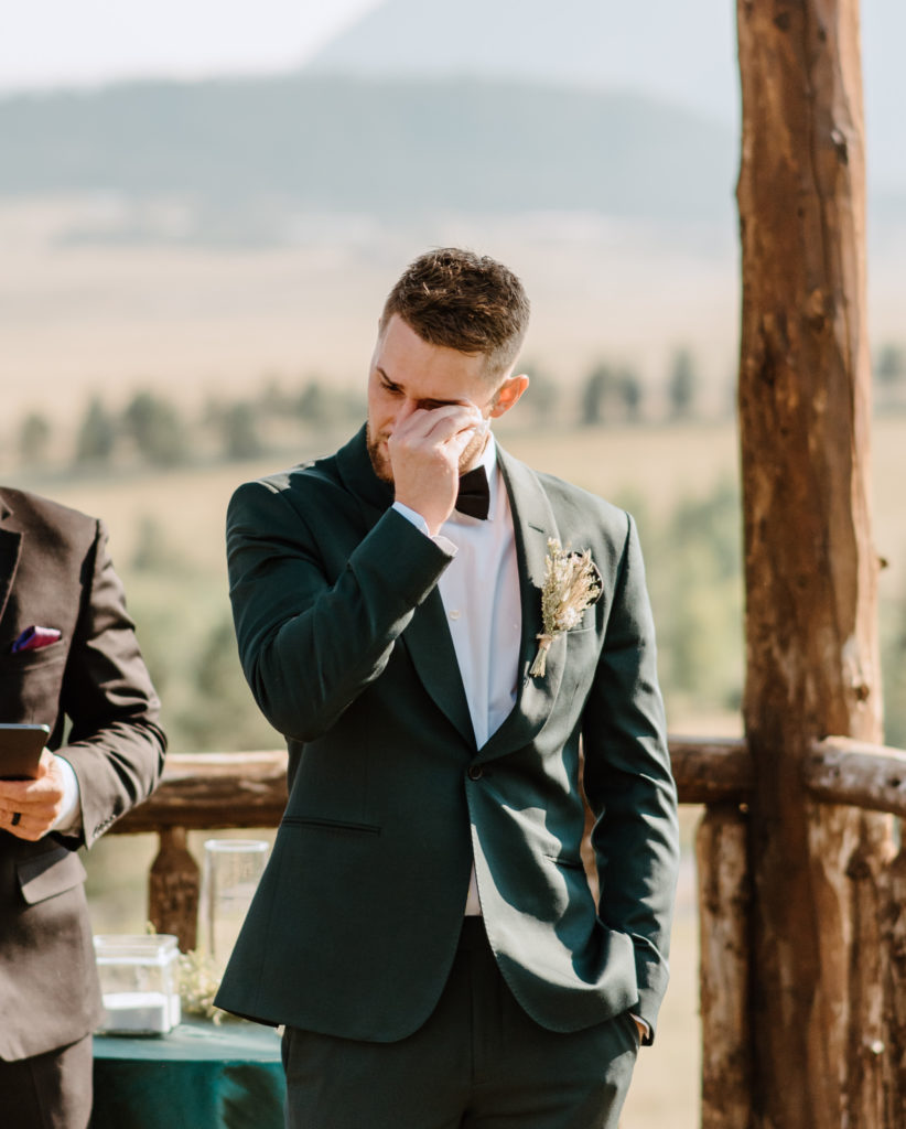 The groom tearing up during the wedding ceremony at Spruce Mountain Ranch