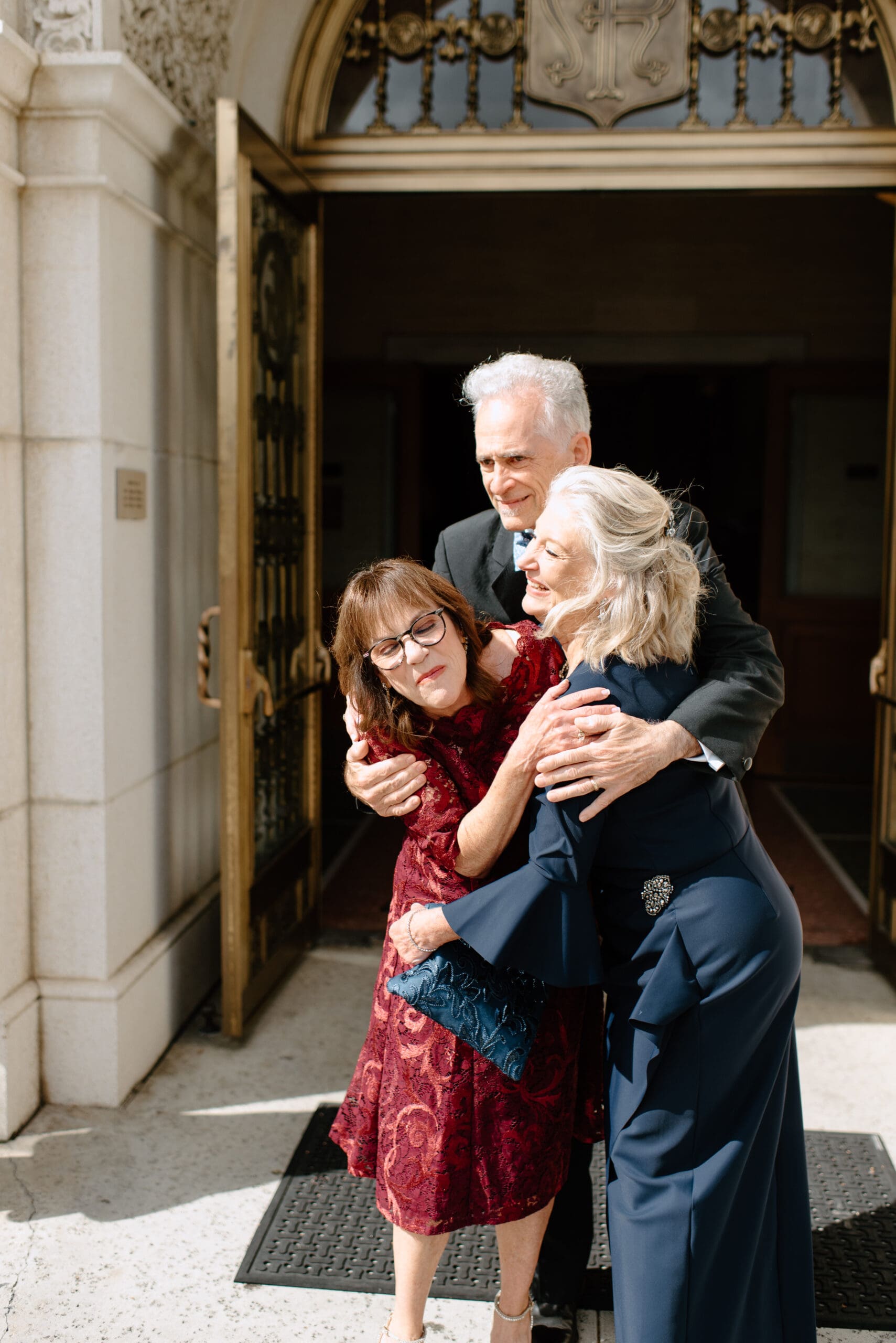 The parents of the bride and groom hugging each other