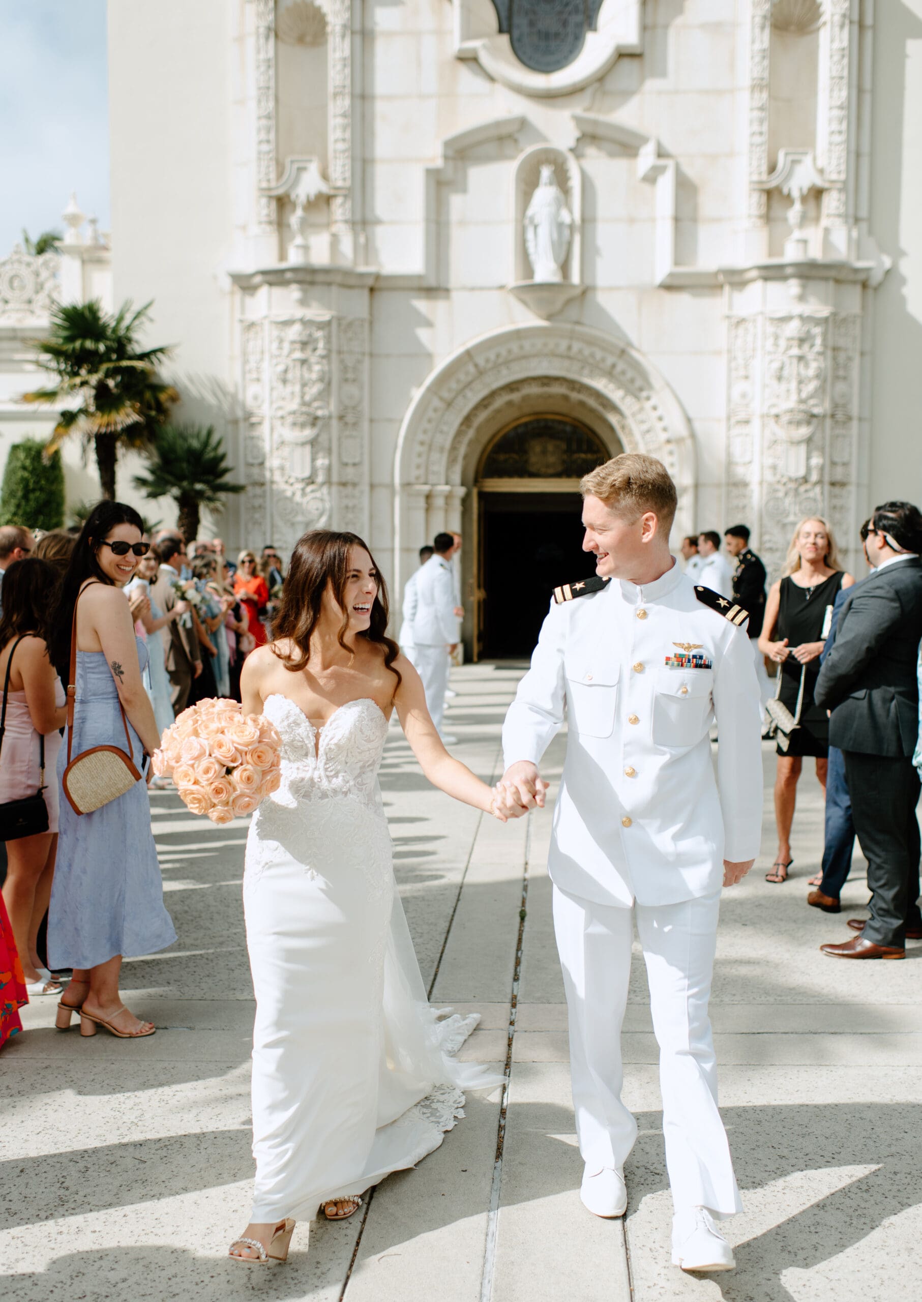 The bride and groom laughing together in front of the church after the ceremony